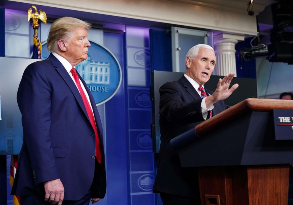 PHOTO: Vice President Mike Pence peaks during the daily briefing on the novel coronavirus while President Donald Trump listens in the Brady Briefing Room at the White House on April 13, 2020, in Washington.