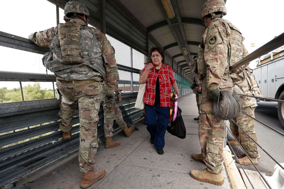 PHOTO: Pedestrians pass members of the U.S.military working to place razor wire along the U.S.-Mexico border on the McAllen-Hidalgo International Bridge, Nov. 2, 2018, in McAllen, Texas.