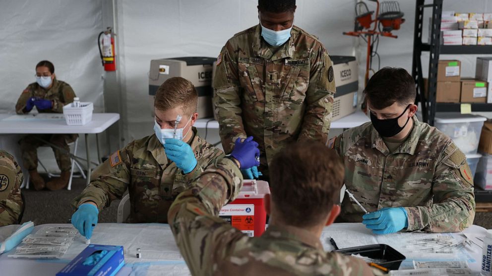 PHOTO: U.S. Army soldiers from the 2nd Armored Brigade Combat Team, 1st Infantry Division, prepare Pfizer COVID-19 vaccines to inoculate people at the Miami Dade College North Campus on March 9, 2021 in Miami.