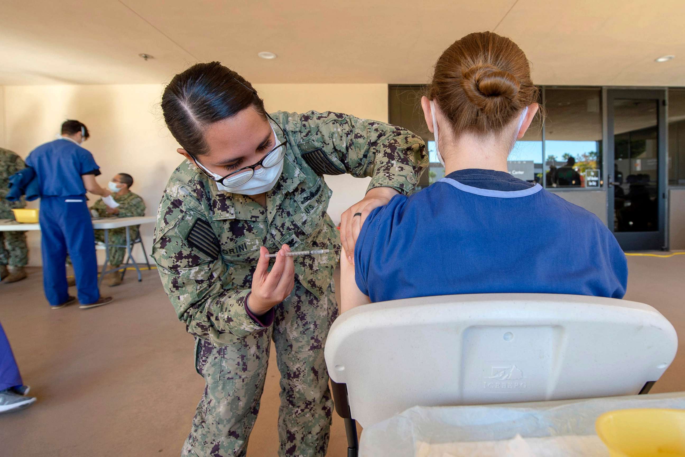 PHOTO: Petty Officer 2nd Class Jasmin Fiorini vaccinates a volunteering service member on Dec. 15, 2020, as part of a vaccination program at the medical center  and Naval Hospital in Camp Pendleton.