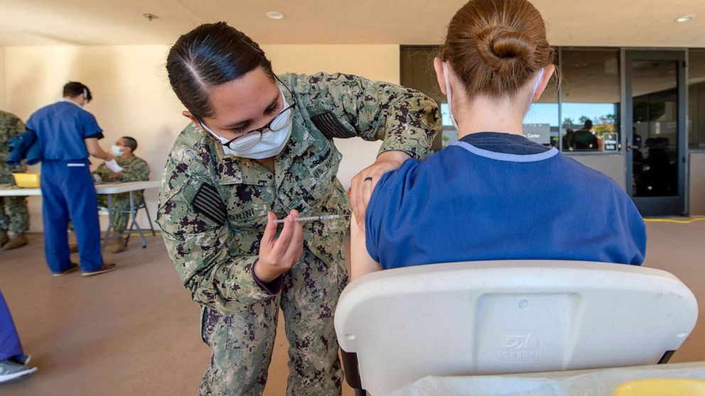 PHOTO: Petty Officer 2nd Class Jasmin Fiorini vaccinates a volunteering service member on Dec. 15, 2020, as part of a vaccination program at the medical center  and Naval Hospital in Camp Pendleton.