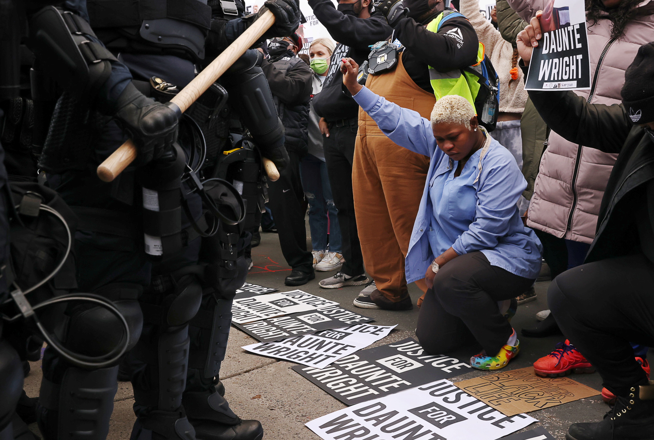 PHOTO: Evelyn Jarbah kneels as protesters take a moment of silence during a rally outside Brooklyn Center Police Department, a day after Daunte Wright was shot and killed by a police officer, in Brooklyn Center, Minn., April 12, 2021.