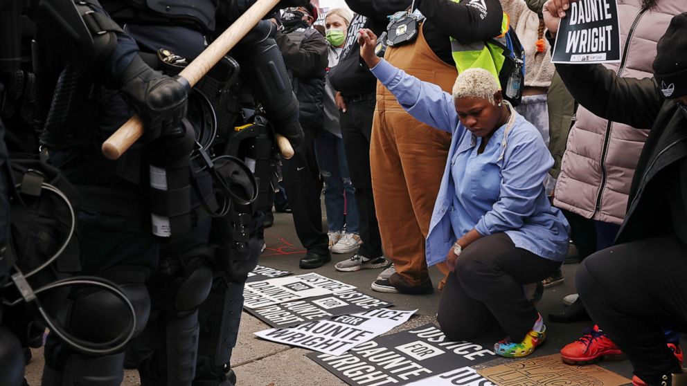 PHOTO: Evelyn Jarbah kneels as protesters take a moment of silence during a rally outside Brooklyn Center Police Department, a day after Daunte Wright was shot and killed by a police officer, in Brooklyn Center, Minn., April 12, 2021.