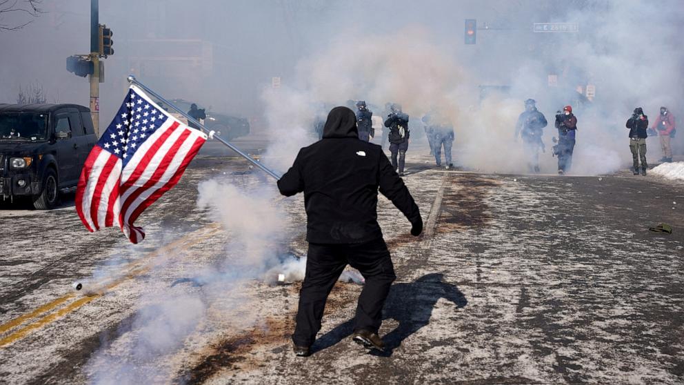 PHOTO: A person holds a U.S. flag during clashes between federal agents and community members at the scene where federal agents fatally shot a man while trying to detain him, in Minneapolis, Minnesota, Jan. 24, 2026.
