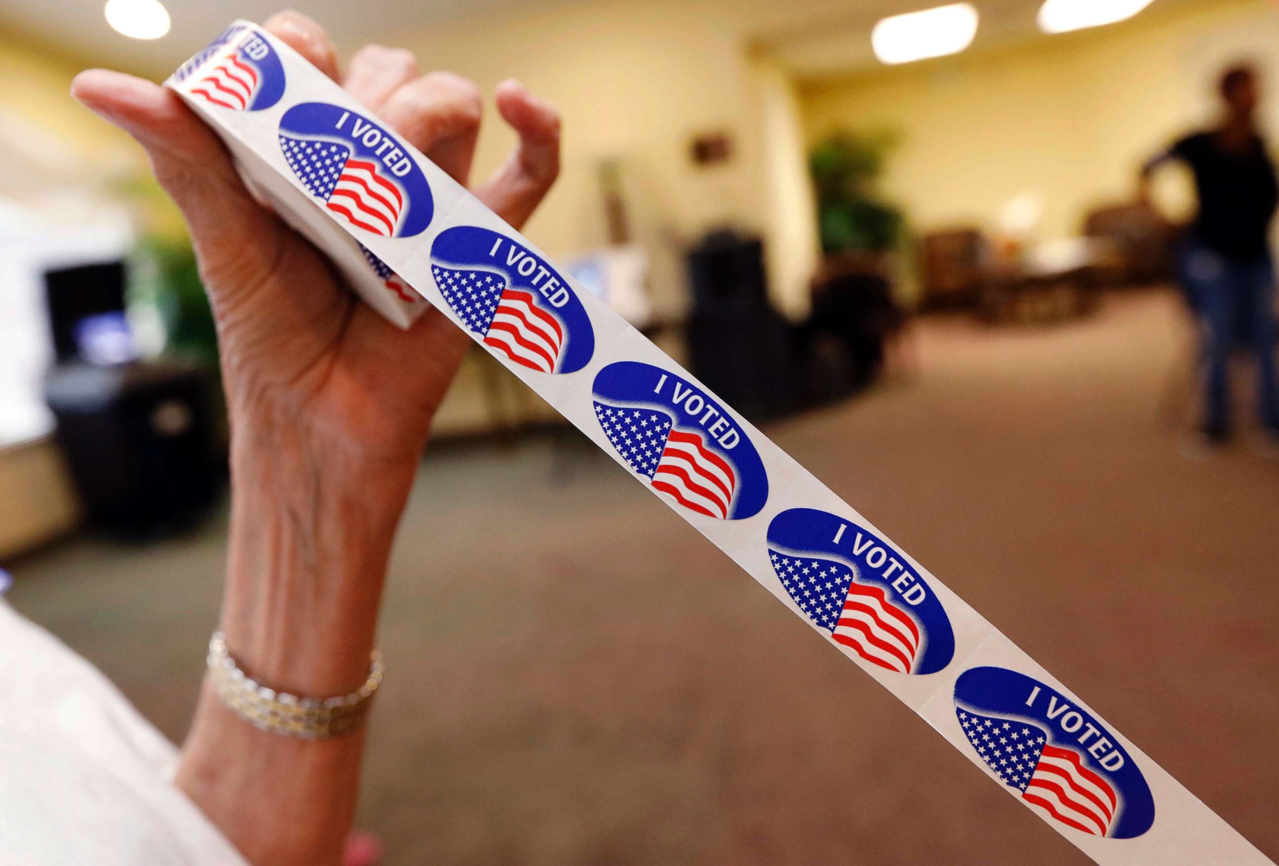 PHOTO: Madison County election bailiff Shirley Lewis unrolls several "I Voted" stickers that they give to each person who votes in their respective party in the Mississippi primary, June 5, 2018, in Madison, Miss.