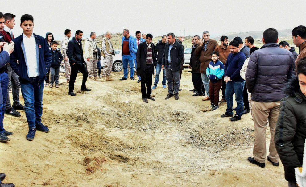 PHOTO: Iraqi Kurds inspect a crater caused by a reportedly Iranian missile initially fired at Iraqi bases housing US and other US-led coalition troops, in the Iraqi Kurdish town of Bardarash in the Dohuk governorate on Jan. 8, 2020.