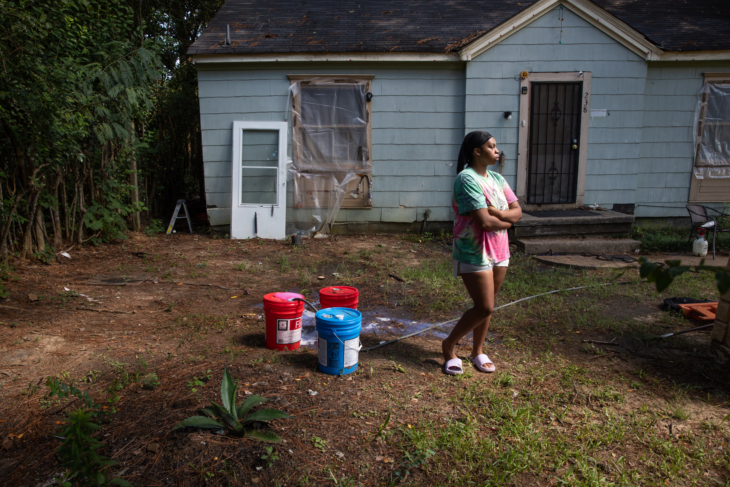PHOTO: In this Aug. 31, 2022, file photo, Seresa McCaskill cleans and refills buckets of water in her front yard in South Jackson, Miss.