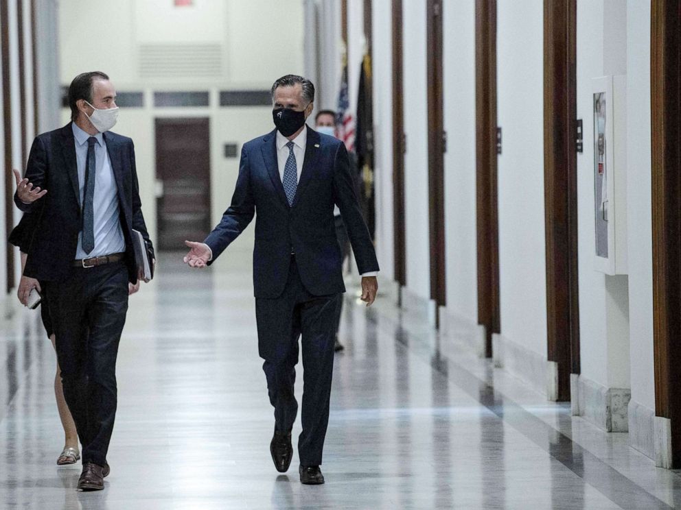 PHOTO: Sen. Mitt Romney speaks with an aide as he walks to his office on Capitol Hill in Washington, DC, Sept. 22, 2020.