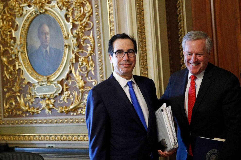 PHOTO: Treasury Secretary Steve Mnuchin, left, and acting White House chief of staff Mark Meadows step out of a meeting on Capitol Hill in Washington, March 24, 2020, as the Senate works to pass a coronavirus relief bill.