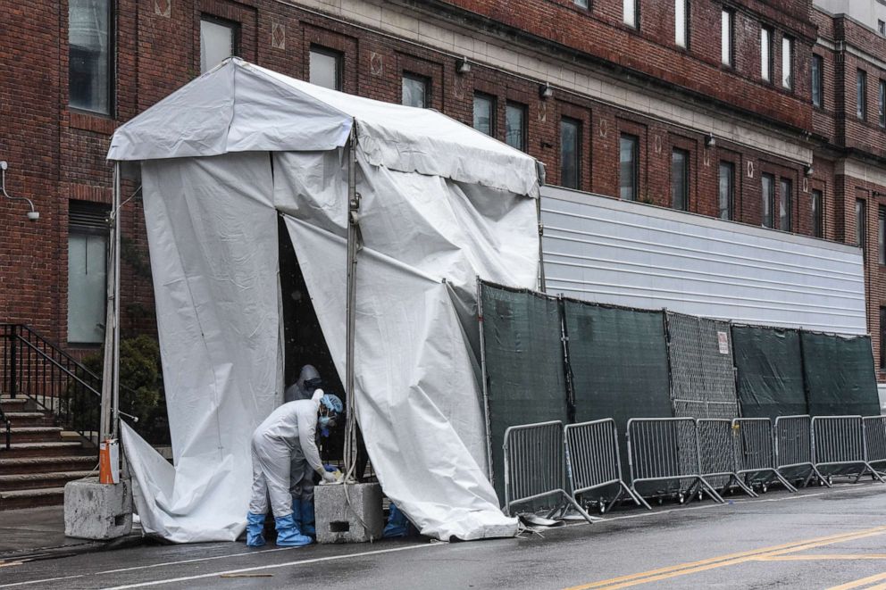 PHOTO: A medical worker approaches a refrigerator truck being used as a morgue outside of Brooklyn Hospital Center amid the coronavirus pandemic on April 3, 2020, in New York.