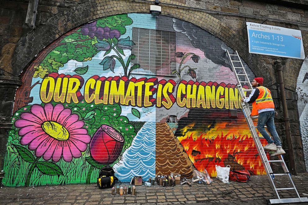 PHOTO: An artist paints a mural on a a wall near the Scottish Events Centre (SEC) which will be hosting the COP26 UN Climate Summit later this month, Oct. 13, 2021, in Glasgow, Scotland.