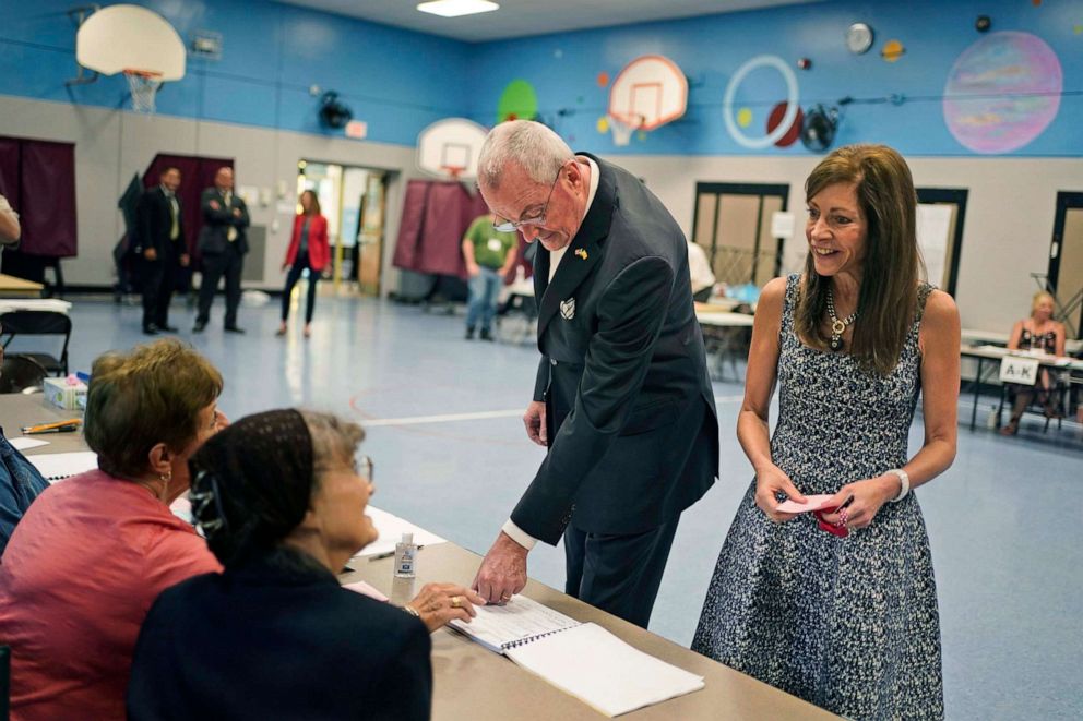PHOTO: New Jersey Gov. Phil Murphy, second from right, and his wife Tammy Murphy talk with poll workers before voting in Red Bank, N.J., June 8, 2021. 
