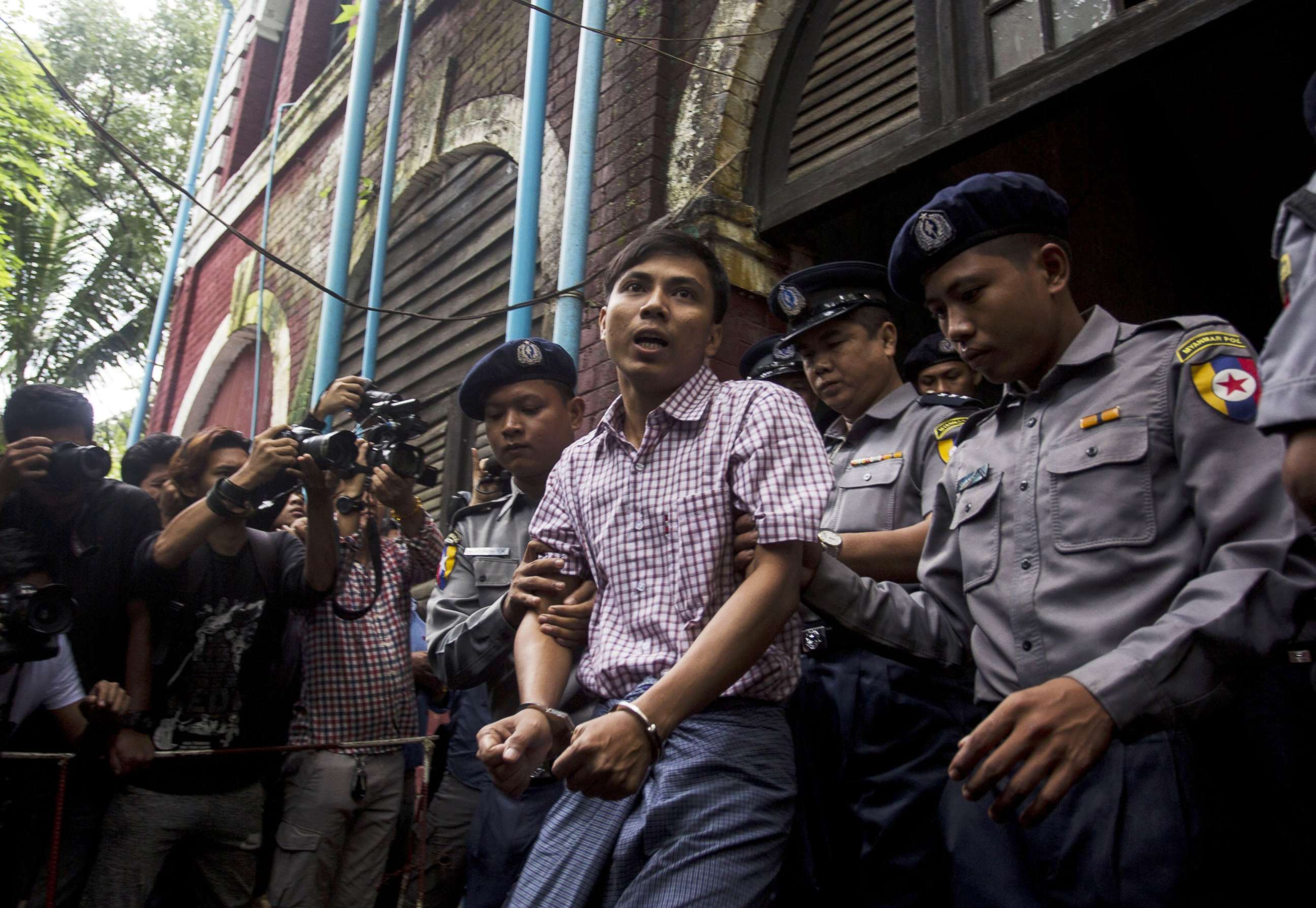PHOTO: Detained Myanmar journalist Kyaw Soe Oo (C) is escorted by police out of a court in Yangon, Aug. 27, 2018.