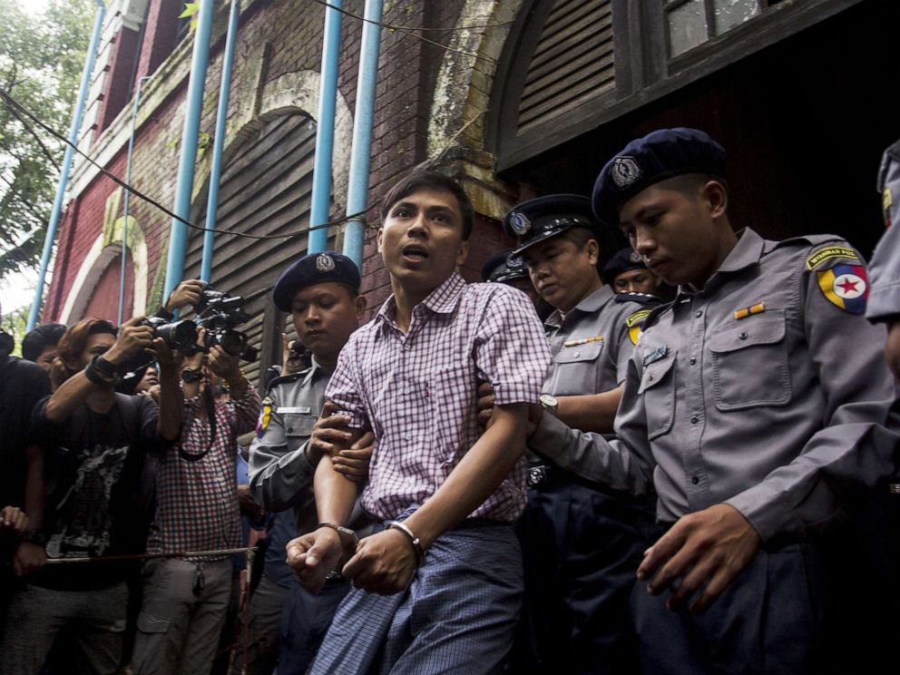 PHOTO: Detained Myanmar journalist Kyaw Soe Oo (C) is escorted by police out of a court in Yangon, Aug. 27, 2018.