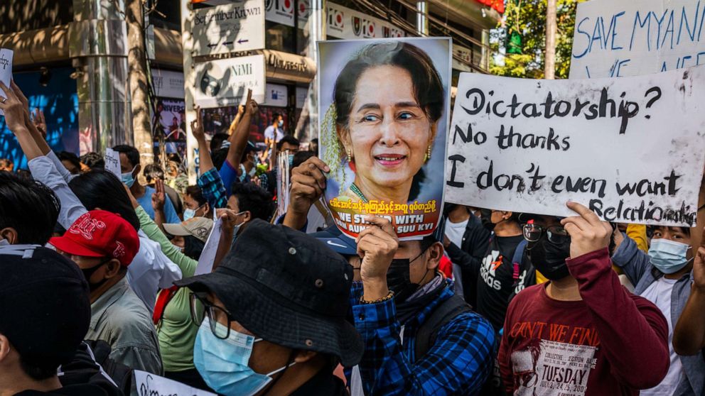 PHOTO: Protesters hold images of de-facto leader Aung San Suu Kyi, Feb. 10, 2021, in Yangon, Myanmar.