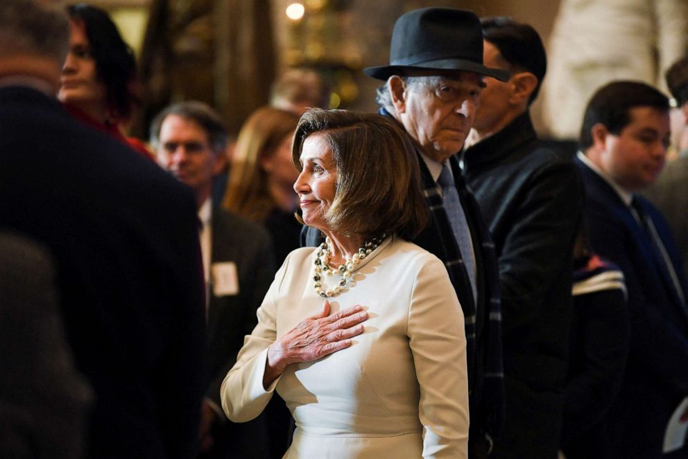 PHOTO: House Speaker Nancy Pelosi (D-CA) watches the color guard arrive before a portrait of her is unveiled at Statuary Hall in the U.S. Capitol, U.S., Dec. 14, 2022.