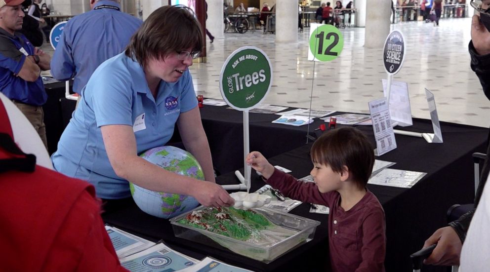 PHOTO: NASA specialist demonstrating earth's rain cycle to a young visitor at Earth Day Celebration inside Union Station, Washington, D.C., on April 22nd, 2022. 