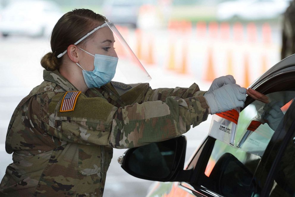 PHOTO: Members of the Illinois National Guard work with the public at the state's new drive-thru COVID-19 testing facility at Rolling Meadows High School, May 22, 2020, in Rolling Meadows, Ill.