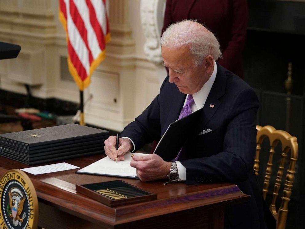 PHOTO: President Joe Biden signs an executive order promoting safe travel as part of the Covid-19 response in the State Dining Room of the White House in Washington, D.C., Jan. 21, 2021.