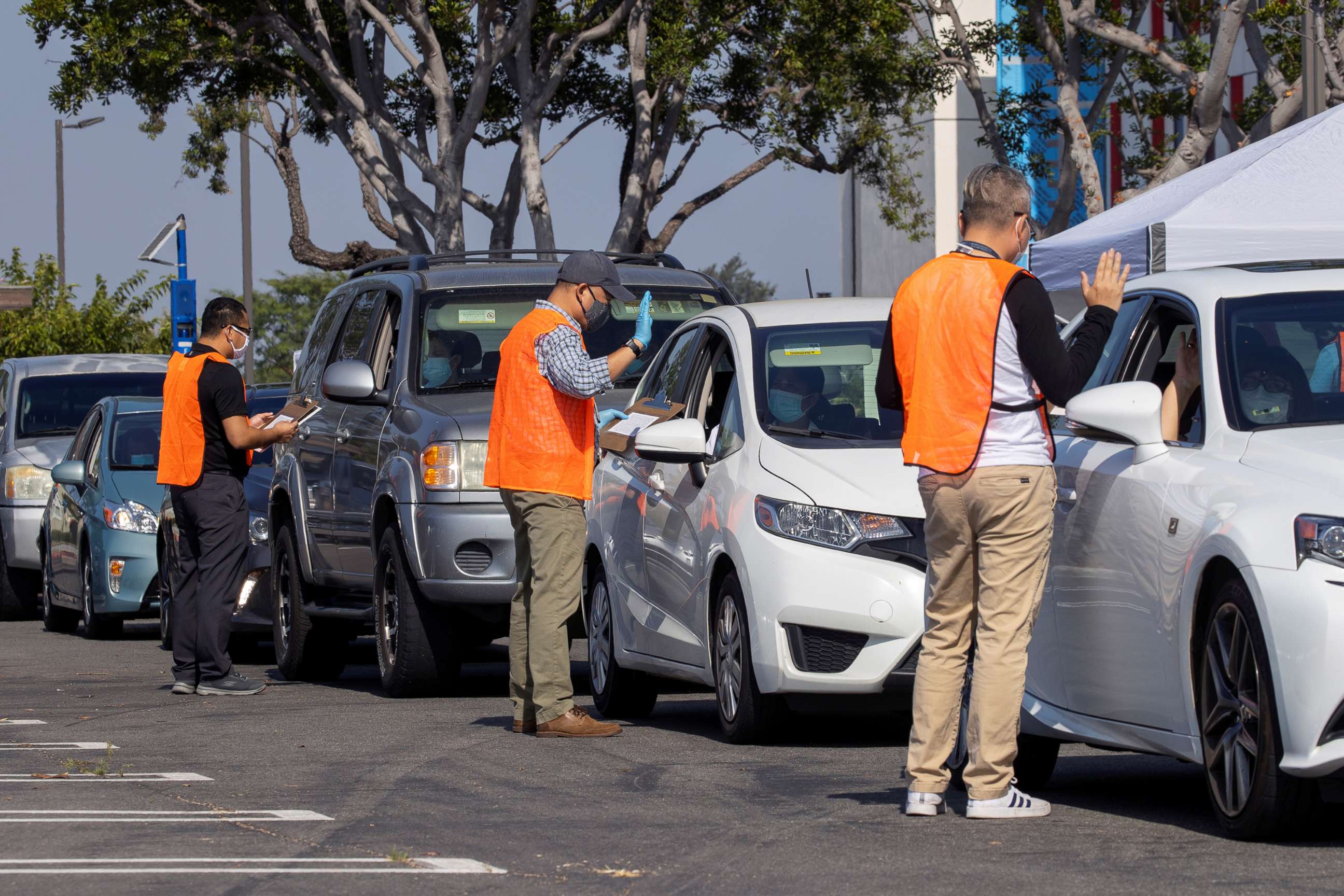 PHOTO: U.S. immigration officers administer the oath as a swearing-in of newly naturalized United States citizens takes place in an empty parking lot in Santa Ana, Calif., July 29, 2020.