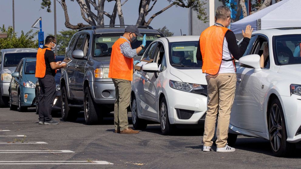 PHOTO: U.S. immigration officers administer the oath as a swearing-in of newly naturalized United States citizens takes place in an empty parking lot in Santa Ana, Calif., July 29, 2020.