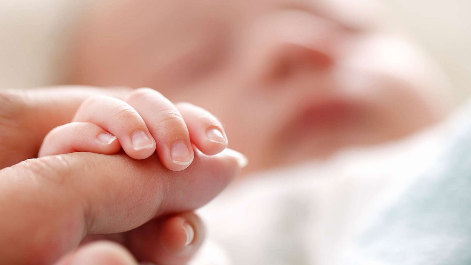 PHOTO: In this undated stock photo a sleeping baby clenches his parent's fingers.