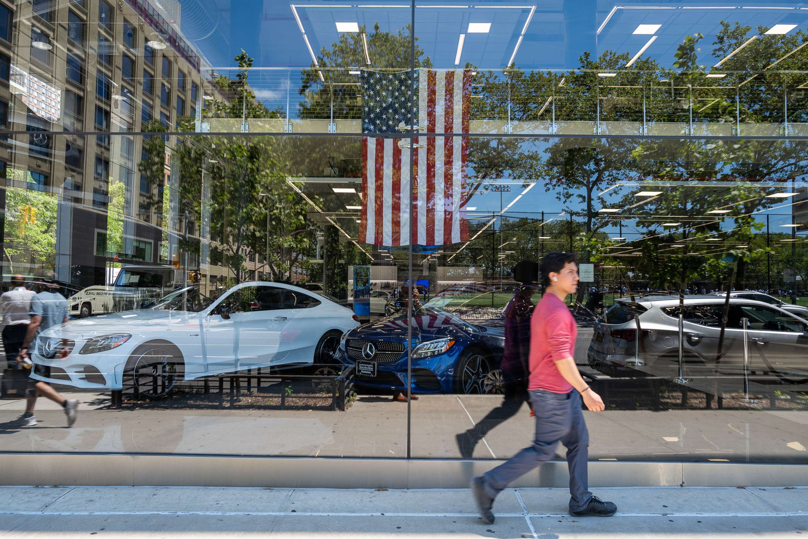 PHOTO: A person walks by a car dealership on June 10, 2022 in New York.