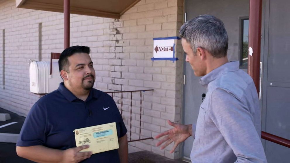 PHOTO: Eduardo Sainz of Phoenix, Ariz., holds up his completed mail-in ballot before delivering it in-person at an early voting location. The 2022 midterms are the first general election for Sainz since he received U.S. citizenship.