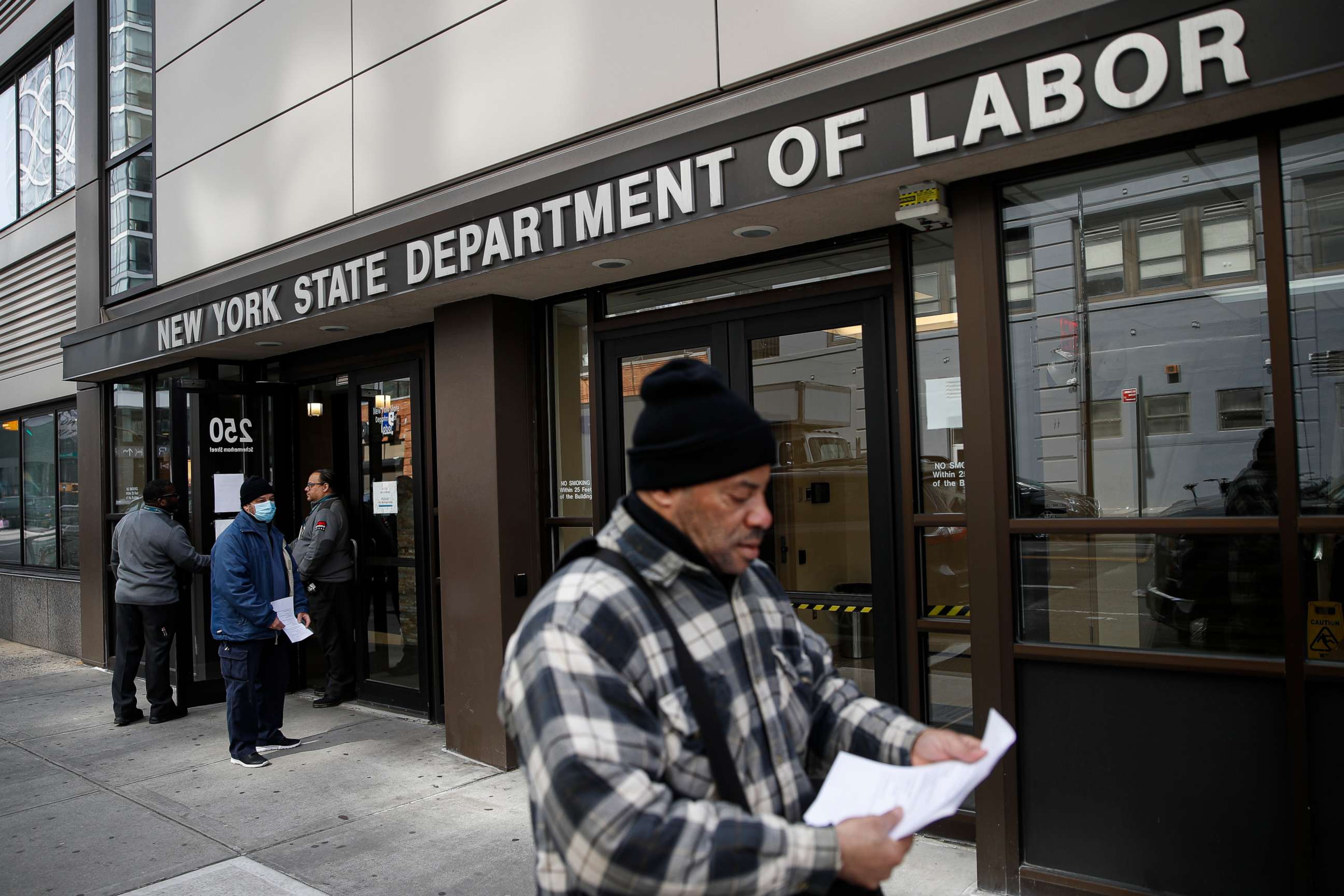 PHOTO: Visitors to the Department of Labor are turned away at the door by personnel due to closures over coronavirus concerns, Wednesday, March 18, 2020, in New York. Applications for jobless benefits are surging as coronavirus concerns shake the economy.