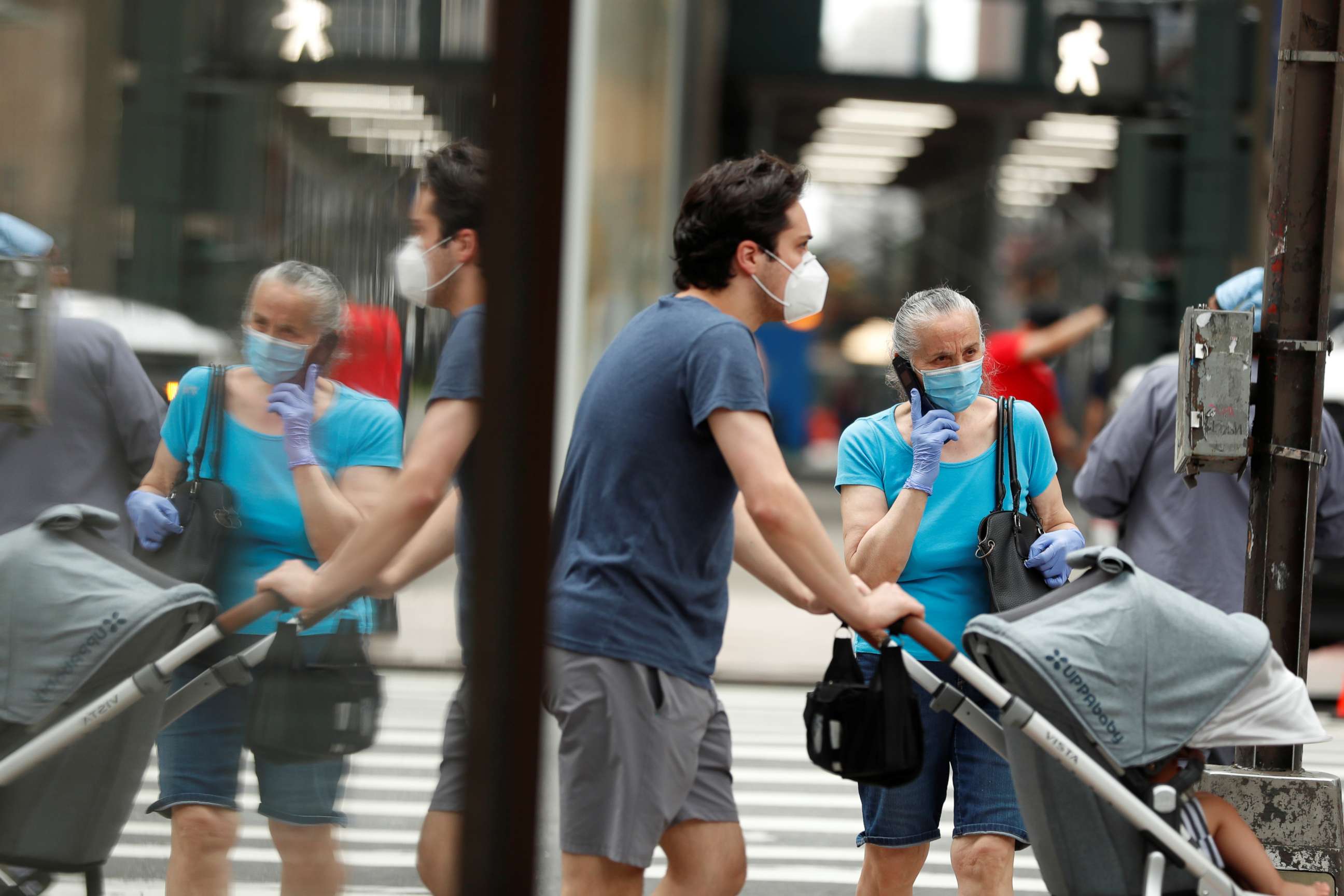 PHOTO: Pedestrians wearing masks walk down the sidewalk  in the Manhattan borough of New York, July 1, 2020.