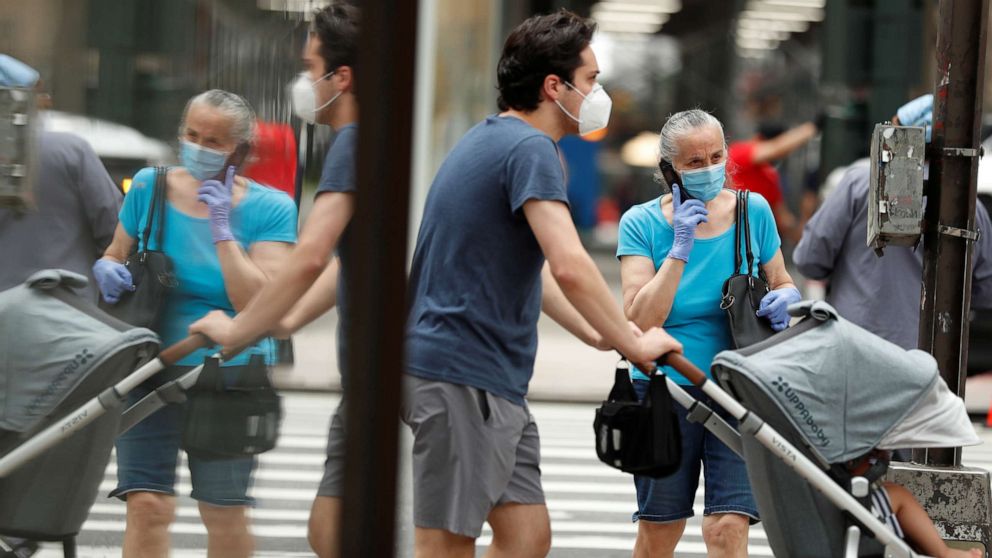 PHOTO: Pedestrians wearing masks walk down the sidewalk  in the Manhattan borough of New York, July 1, 2020.