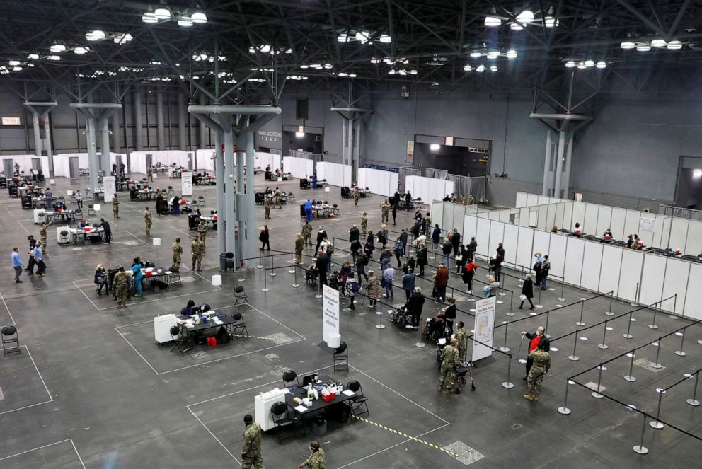 PHOTO: People line up as health care workers and military personnel work to distribute doses of the COVID-19 vaccine at the New York State COVID-19 vaccination site at the Jacob K. Javits Convention Center, in New York, Jan. 13, 2021.