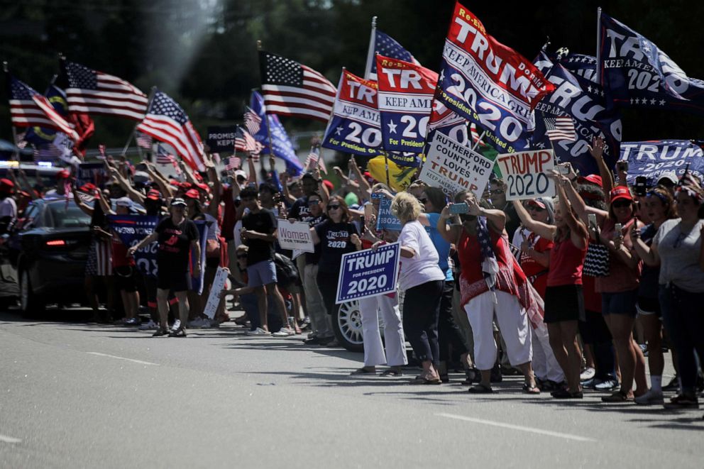 PHOTO: Supporters watch as the motorcade of President Donald Trump passes by on its way to a tour of Fujifilm Diosynth Biotechnologies' Innovation Center in Morrrisville, N.C., July 27, 2020.