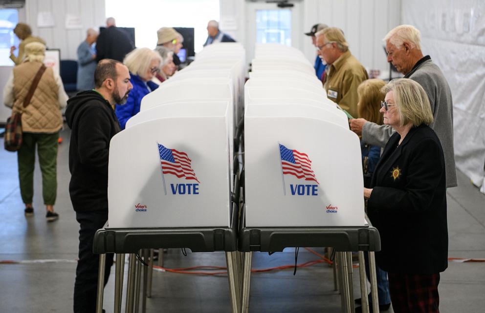 PHOTO: Voters make selections at their voting booths inside an early voting site on Oct. 17, 2024 in Hendersonville, N.C. 