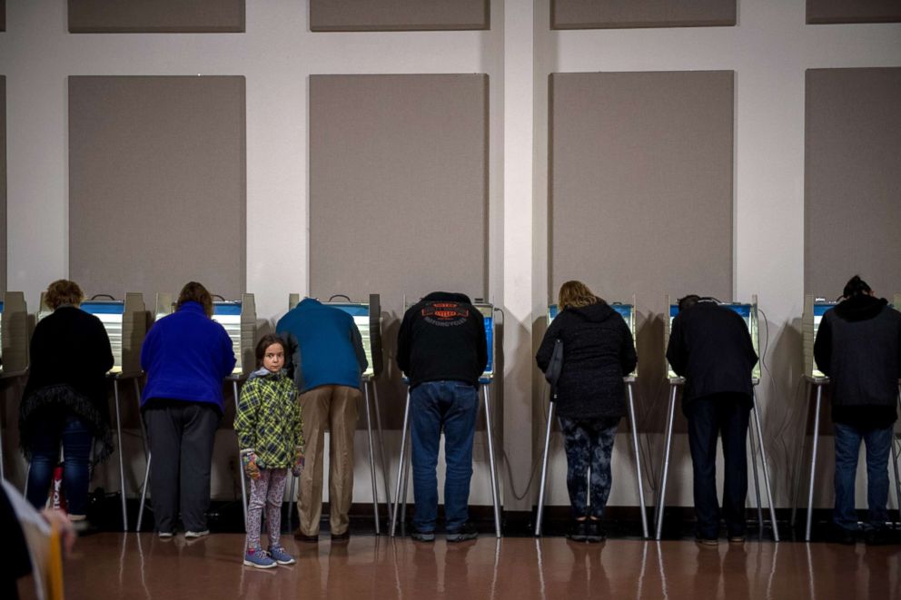 PHOTO: A young girl waits as voters cast their ballots in Bismarck, N.D., on Nov. 6, 2018.