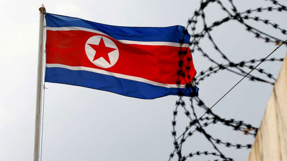 PHOTO: A North Korea flag flies near concertina wire.