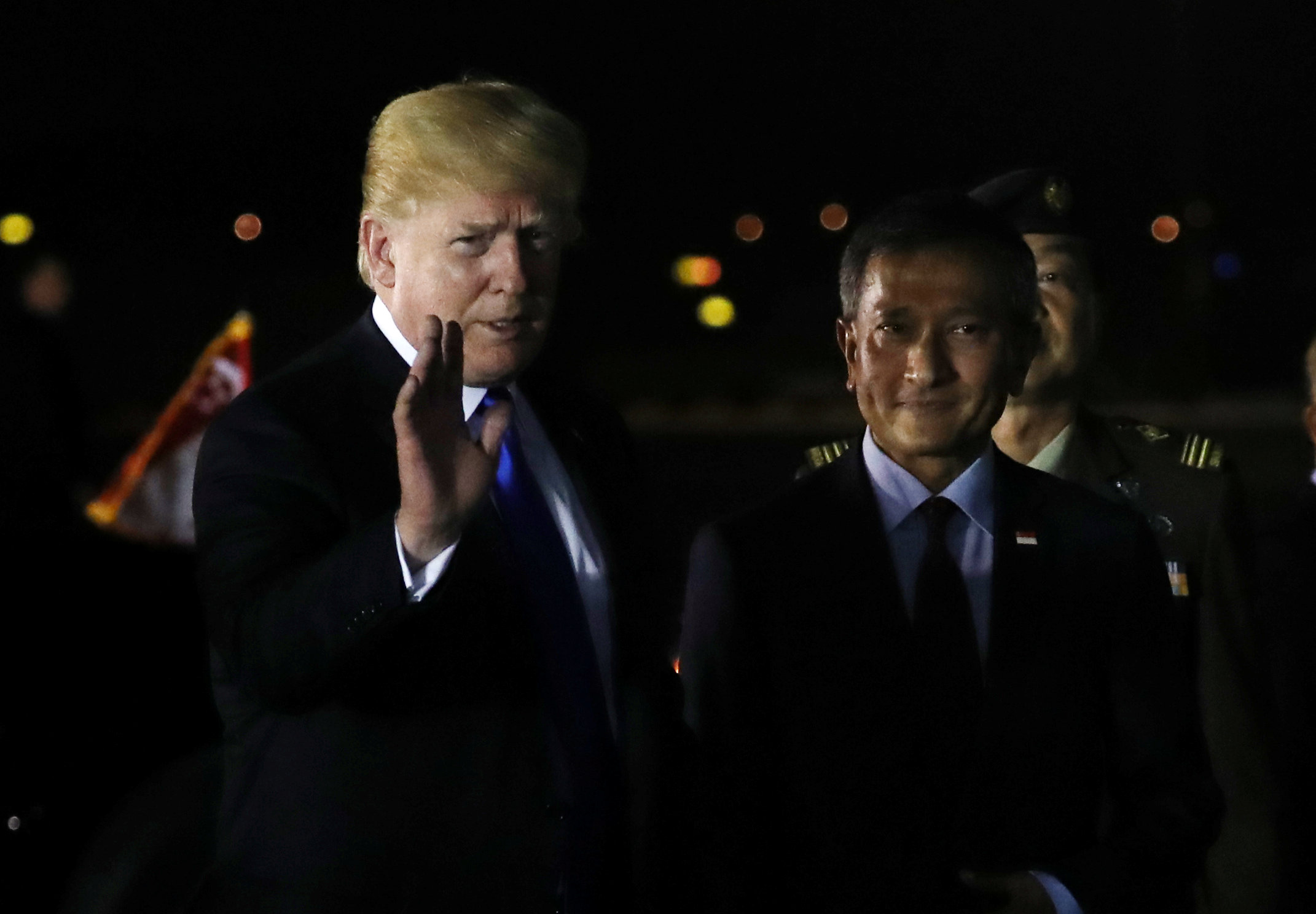 PHOTO: U.S. President Donald Trump waves next to Singapore's Foreign Minister Vivian Balakrishnan after arriving in Singapore, June 10, 2018.