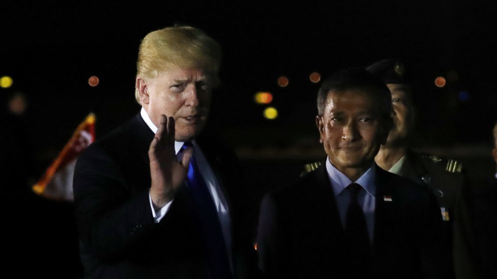 U.S. President Donald Trump waves next to Singapore's Foreign Minister Vivian Balakrishnan after arriving in Singapore, June 10, 2018.