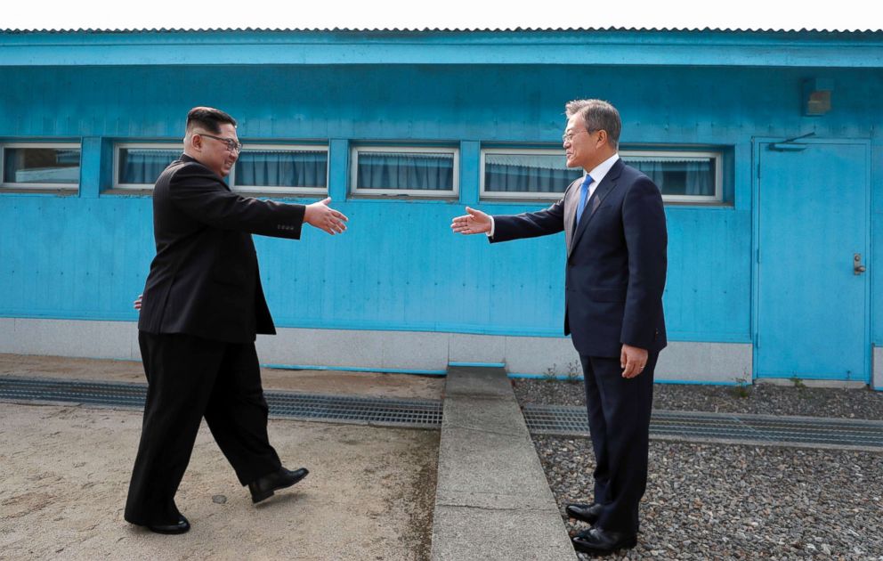 PHOTO: North Korean Leader Kim Jong Un, left, and South Korean President Moon Jae-in shake hands over the military demarcation line upon meeting for the Inter-Korean Summit on April 27, 2018, in Panmunjom, South Korea.