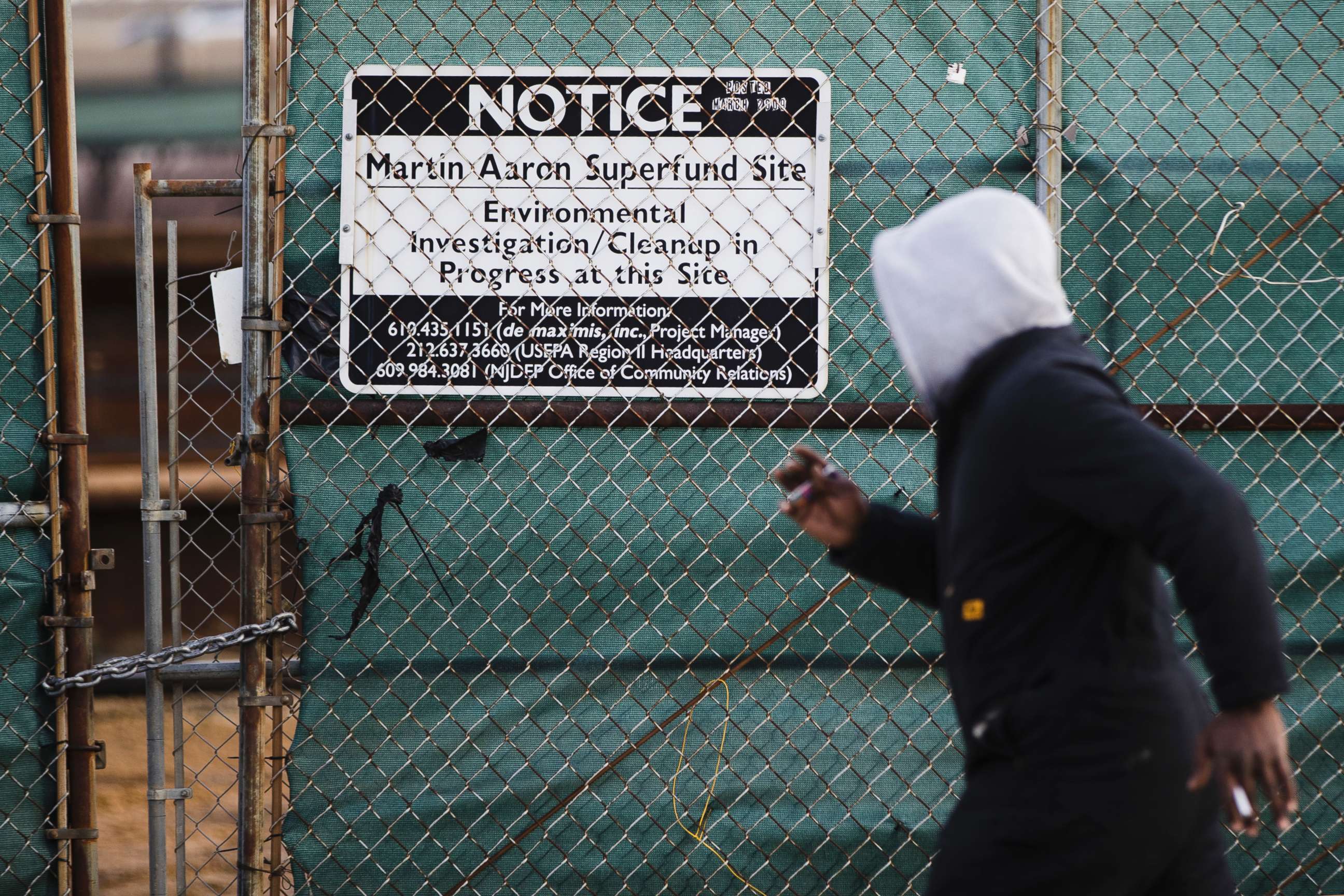 PHOTO: a man walks past a notice for the Martin Aaron Inc. Superfund site in Camden, N.J., Dec. 11, 2017.