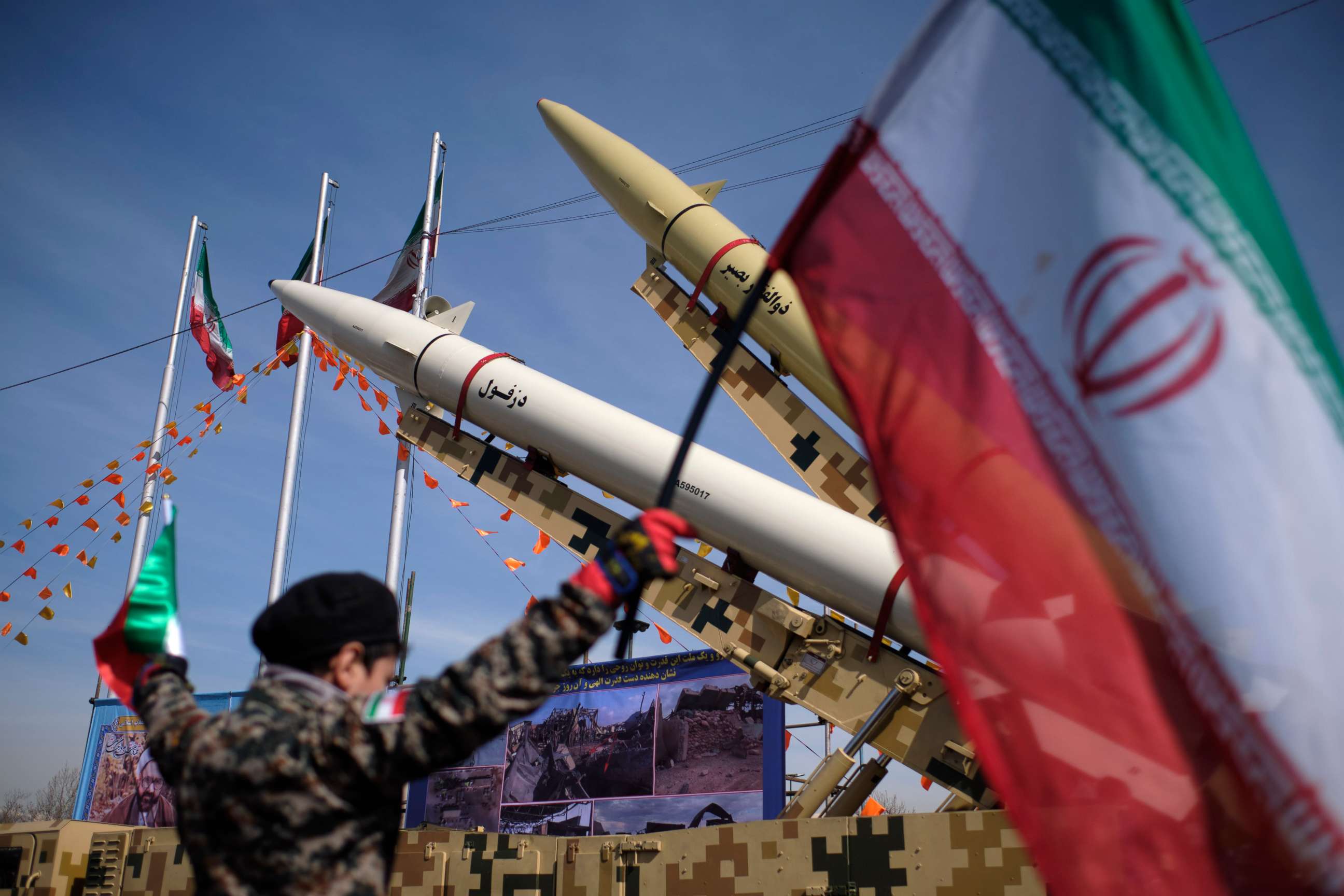 PHOTO: A boy wearing an Islamic Revolutionary Guard Corps uniform holds an Iranian flag while missiles are displayed in Azadi Square during a rally to commemorate the anniversary of the Islamic Revolution, in Tehran, Iran, Feb. 10, 2021.