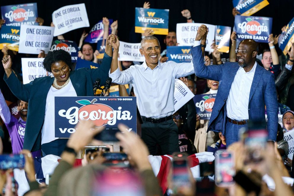 PHOTO: In this Oct. 28, 2022, file photo, former President Barack Obama raises hands with Democratic Gubernatorial candidate Stacey Abrams and Sen. Raphael Warnock at a campaign event for Georgia Democrats in College Park, Ga.