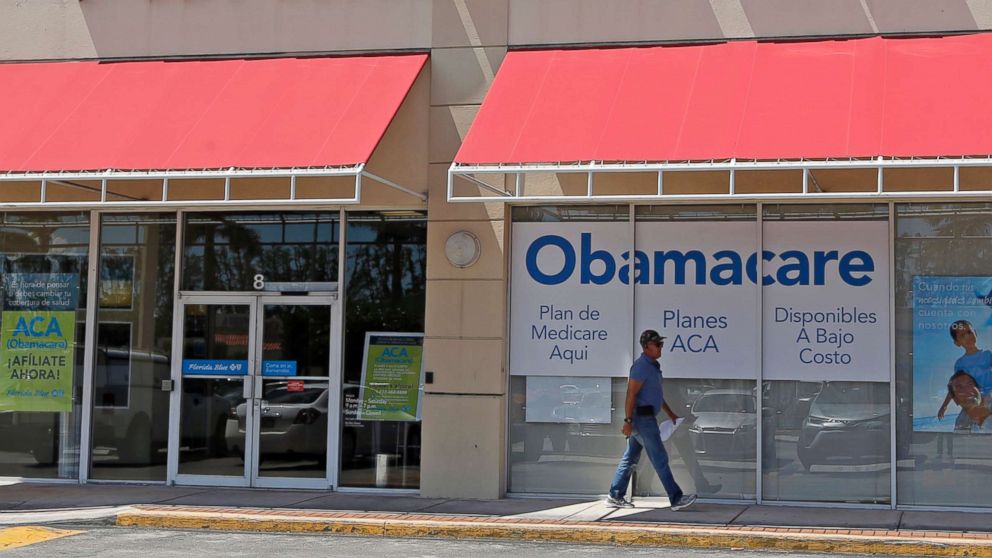 PHOTO: A person walks by a health care insurance office in Hialeah, Fla. on July 27, 2017.