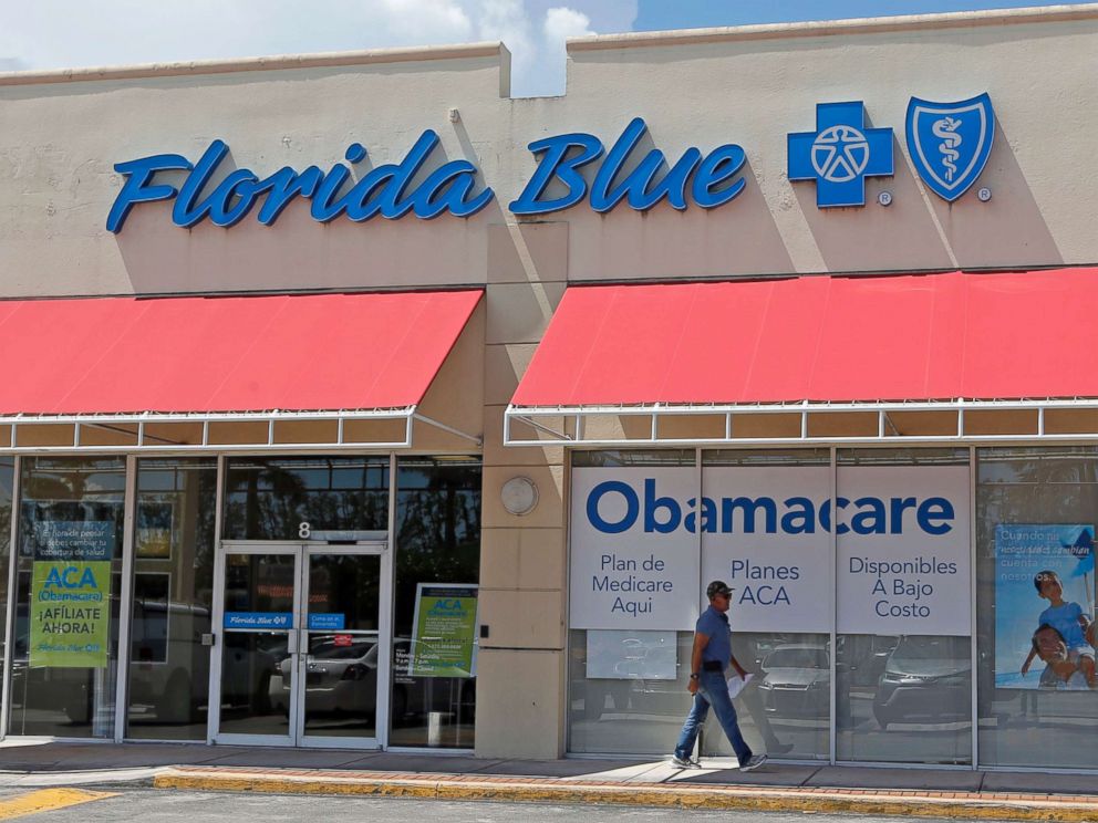 PHOTO: A person walks by a health care insurance office in Hialeah, Fla. on July 27, 2017.