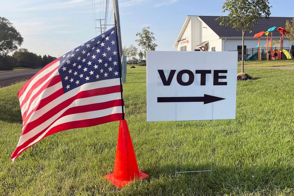 PHOTO: An American flag waves in the breeze next to a sign directing Ohioans to vote inside Tharp Sixth Grade School, Aug. 8, 2023 in Hilliard, Ohio.