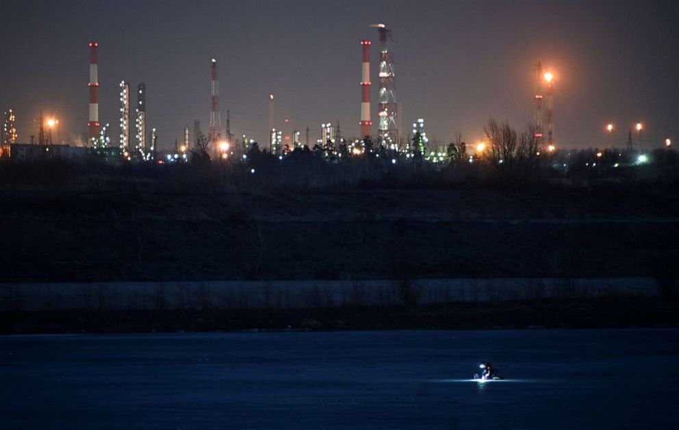 PHOTO: A fisherman is seen on the ice-covered Irtysh River near an oil refinery in Omsk, Russia, April 15, 2021.