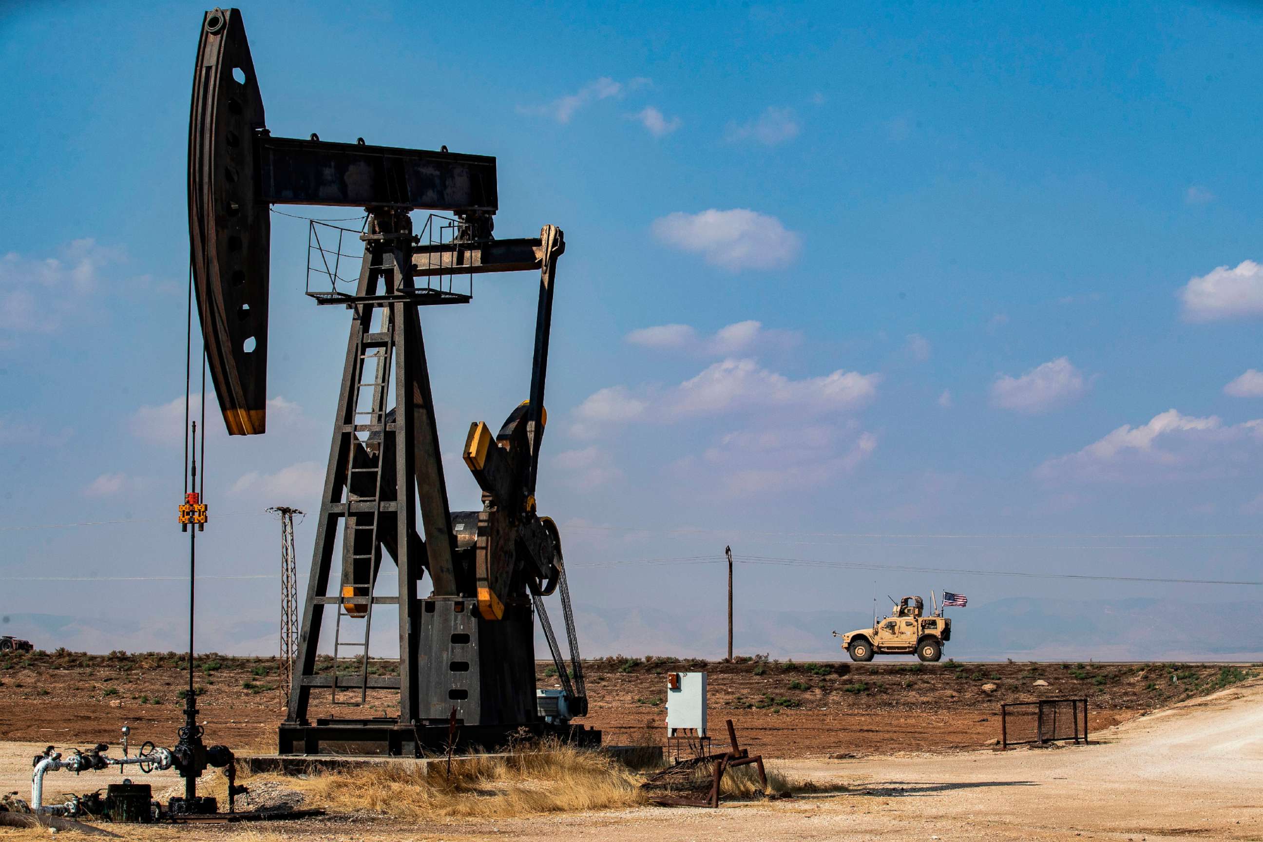 PHOTO: A U.S. military vehicle, part of a convoy arriving from northern Iraq, drives past an oil pump jack in the countryside of Syria's northeastern city of Qamishli, Oct. 26, 2019.