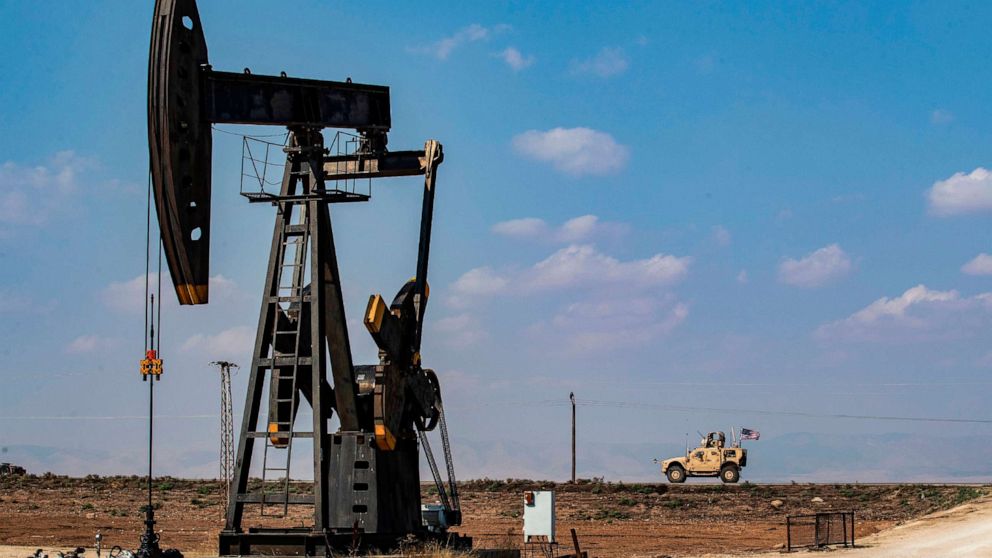 PHOTO: A U.S. military vehicle, part of a convoy arriving from northern Iraq, drives past an oil pump jack in the countryside of Syria's northeastern city of Qamishli, Oct. 26, 2019.