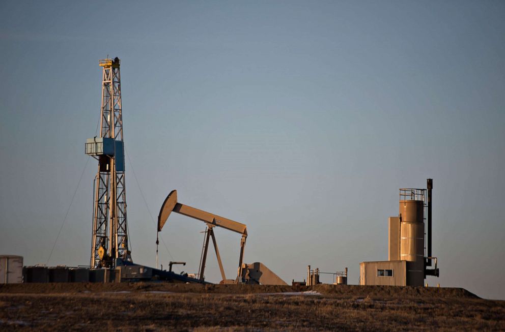 PHOTO: A pumpjacks operates in the foreground of a crude oil drilling rig outside Williston, N.D., Feb. 12, 2015.