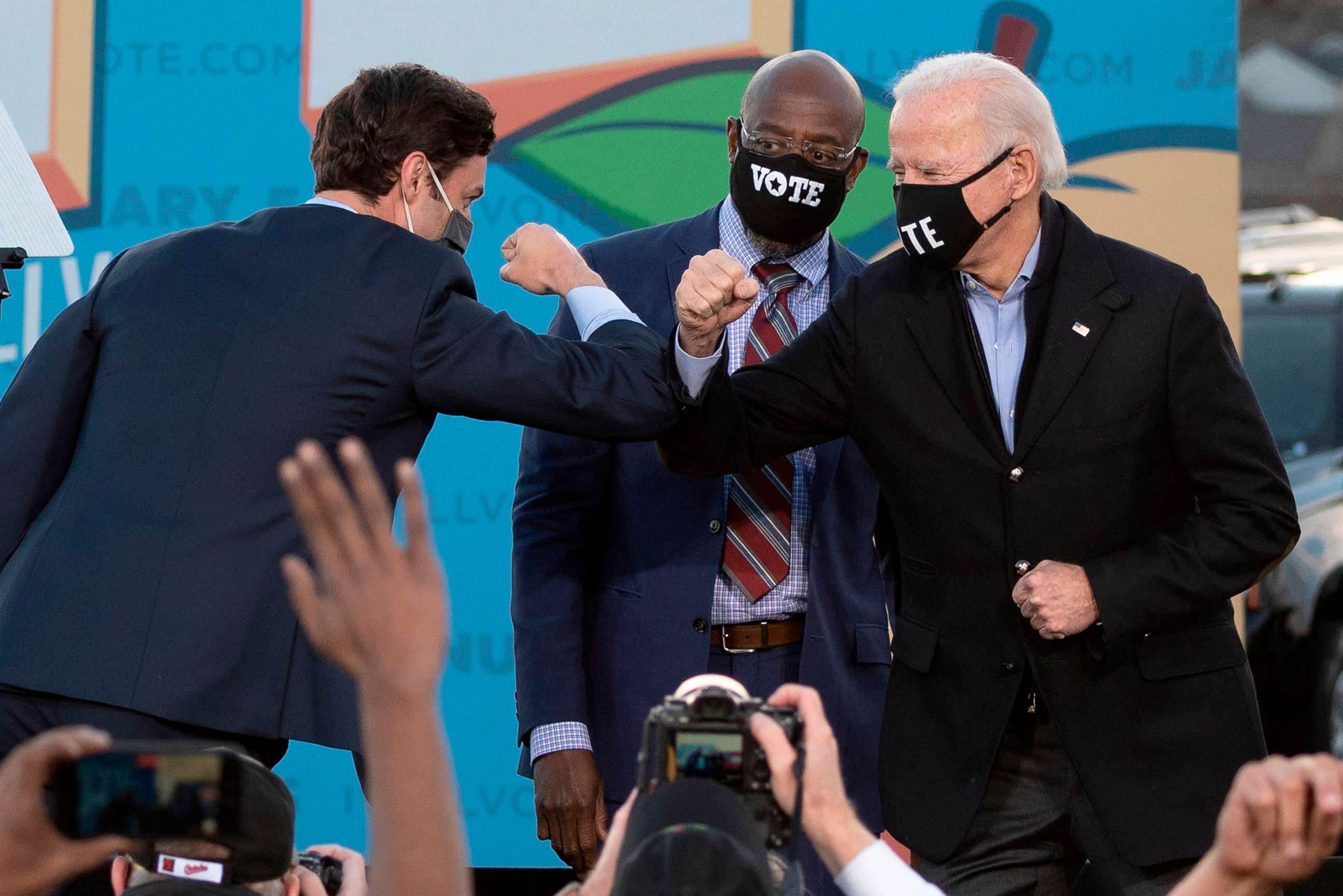 PHOTO: In this Jan. 4, 2021, file photo, Democratic candidates for Senate Jon Ossoff, Raphael Warnock, cener, and President-elect Joe Biden bump elbows on stage during a rally outside Center Parc Stadium in Atlanta.